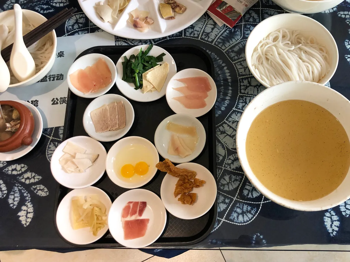 Crossing-the-bridge rice noodles with broth and ingredients served separately
