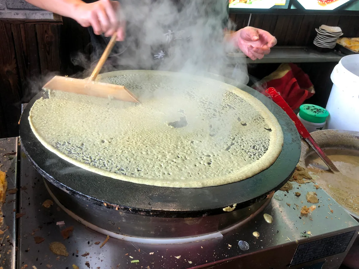 摊在鏊子上的天津煎饼果子