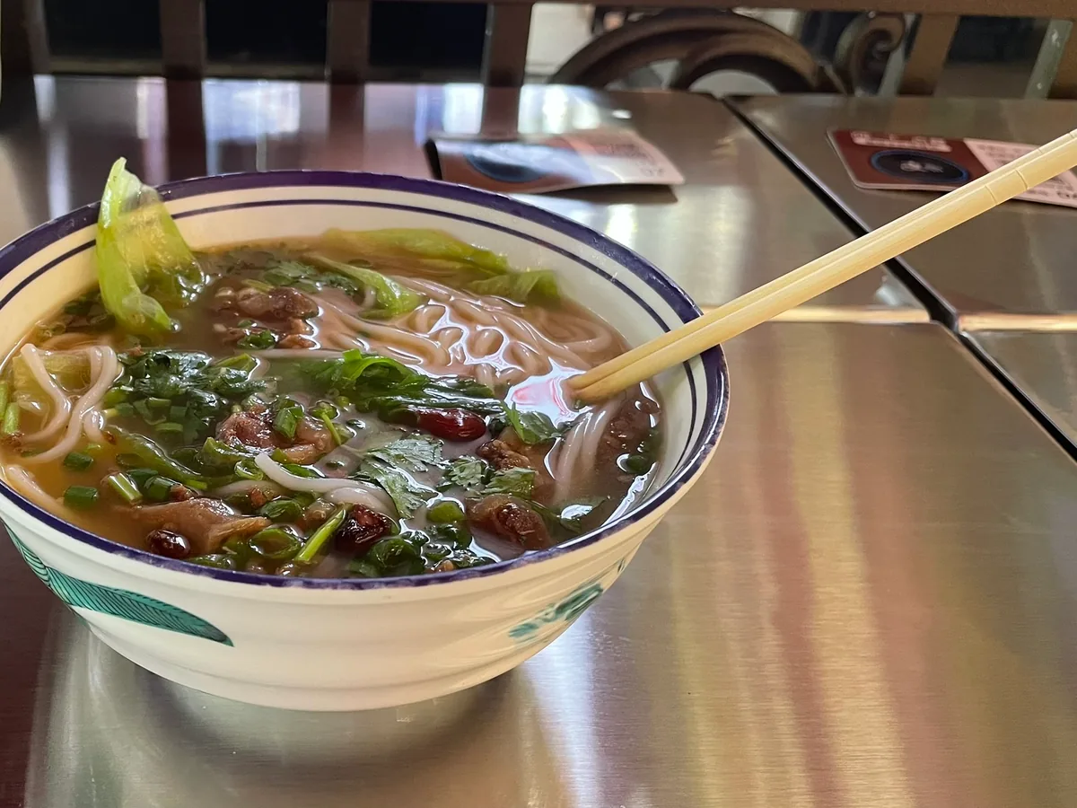 红烧肉酱与青菜搭配的米线